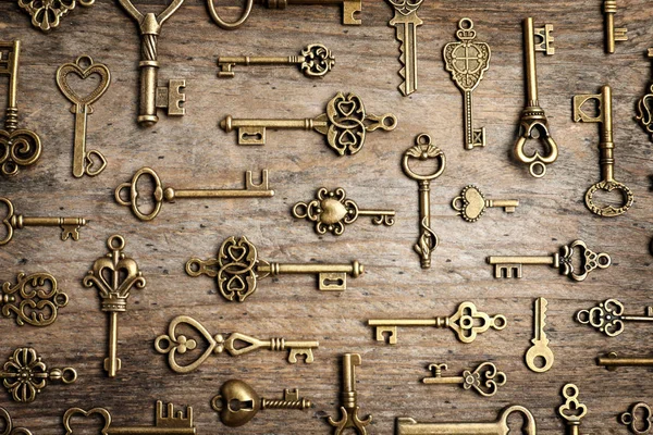 Плоская композиция с старинными ключами на деревянном фоне — стоковое фото