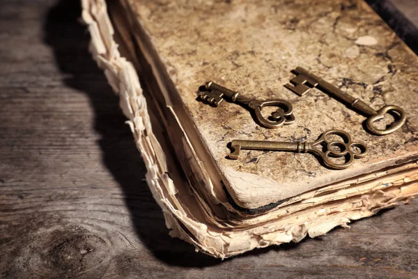 Chaves antigas vintage com livro sobre fundo de madeira, espaço para texto — Fotografia de Stock