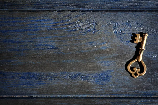Old vintage key on wooden background, top view with space for text — Stock Photo, Image