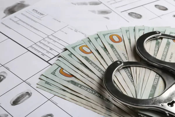 Dinero, esposas y hojas de registro de huellas dactilares, primer plano. Investigación penal — Foto de Stock