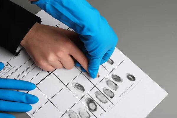 Investigador tomando huellas dactilares del sospechoso en la mesa, primer plano. Experiencia criminal —  Fotos de Stock