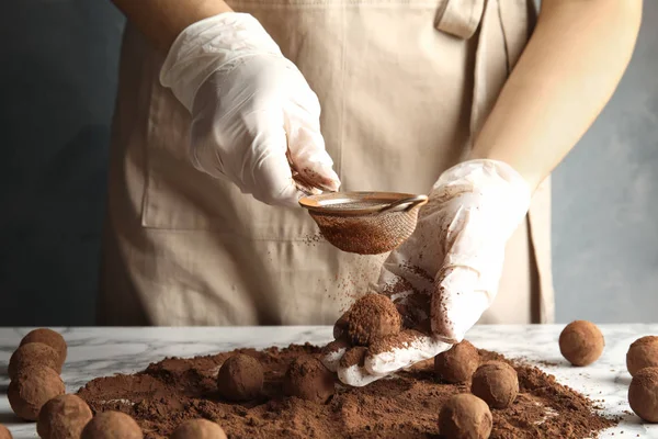 Kadın masada, closeup lezzetli çikolata truffles hazırlanması — Stok fotoğraf