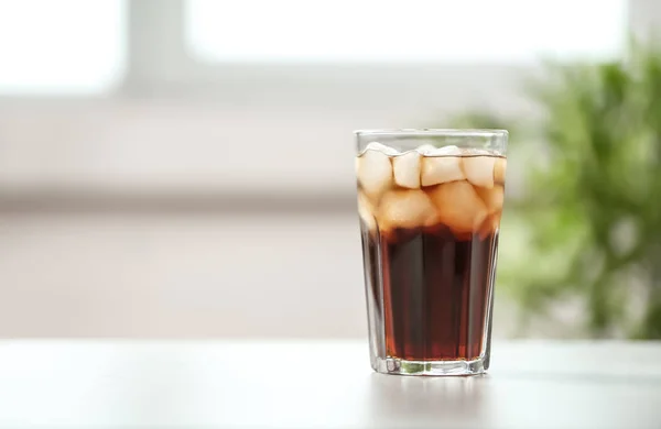 Ποτήρι cola με πάγο στο τραπέζι θολή φόντο, χώρο για το κείμενο — Φωτογραφία Αρχείου