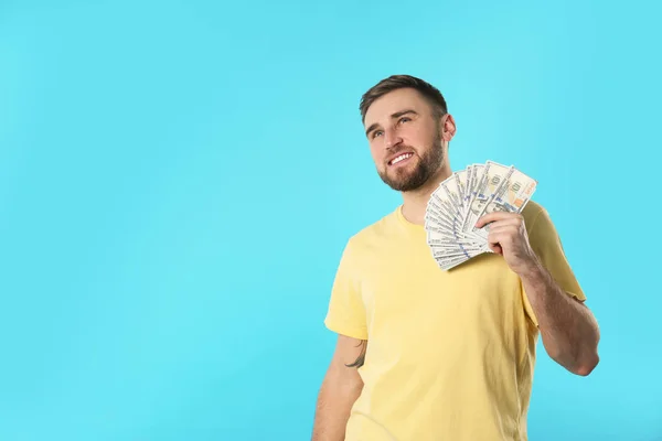 Portrait of happy young man with money on color background. Space for text — Stock Photo, Image