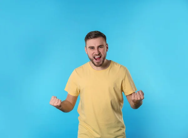 Portrait de jeune homme émotionnel sur fond de couleur — Photo