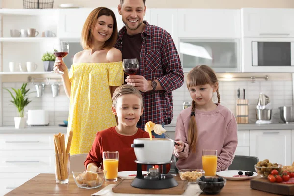 Lycklig familj njuter fondue middag hemma — Stockfoto