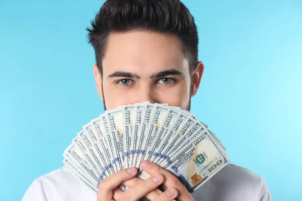 Retrato de joven feliz con dinero en el fondo de color —  Fotos de Stock