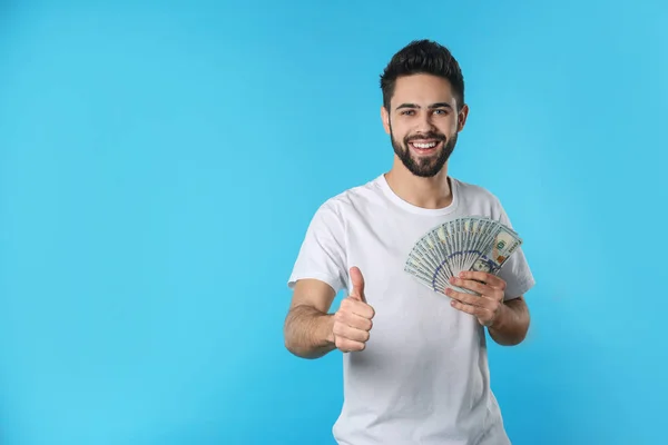 Porträt eines glücklichen jungen Mannes mit Geld auf farbigem Hintergrund. Raum für Text — Stockfoto