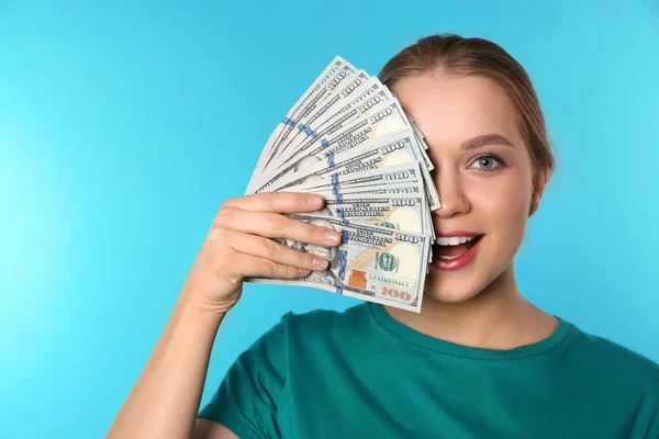 Portrait of happy young woman with money on color background. Space for text — Stock Photo, Image