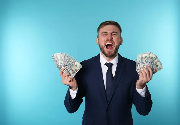 Πορτρέτο του συναισθηματική νεαρός επιχειρηματίας με τα χρήματα σε χρώμα φόντου — Φωτογραφία Αρχείου
