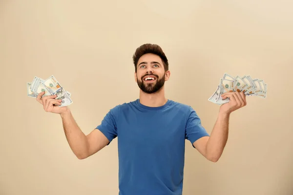 Retrato de joven feliz con dinero en el fondo de color — Foto de Stock