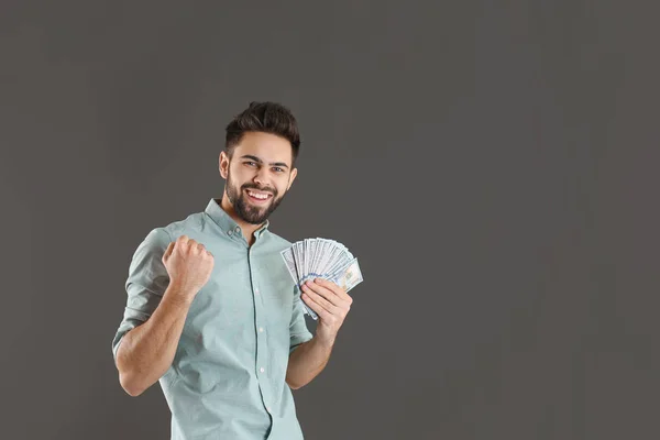 Portrait of happy young man with money on grey background. Space for text — Stock Photo, Image