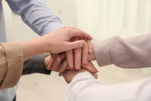 Group of people holding their hands together on blurred background, closeup — Stock Photo, Image