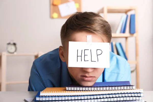 Junger Mann mit Notizblock auf der Stirn am Arbeitsplatz — Stockfoto