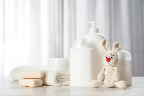 Baby cosmetische producten, speelgoed en handdoek op tafel binnenshuis — Stockfoto