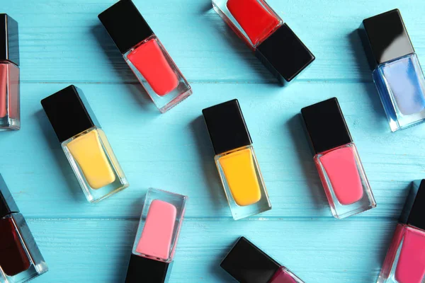 Bottles of nail polish on color background, top view — Stock Photo, Image