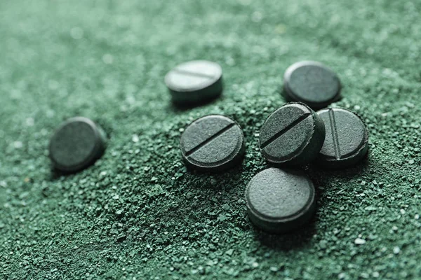 Natural green spirulina powder and pills as background, closeup — Stock Photo, Image