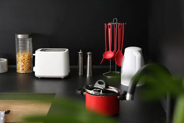Стильный кухонный стол с посудой и бытовой техникой — стоковое фото