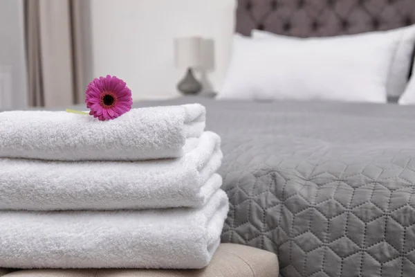 Stack of fresh towels on bedside bench in hotel room — Stock Photo, Image