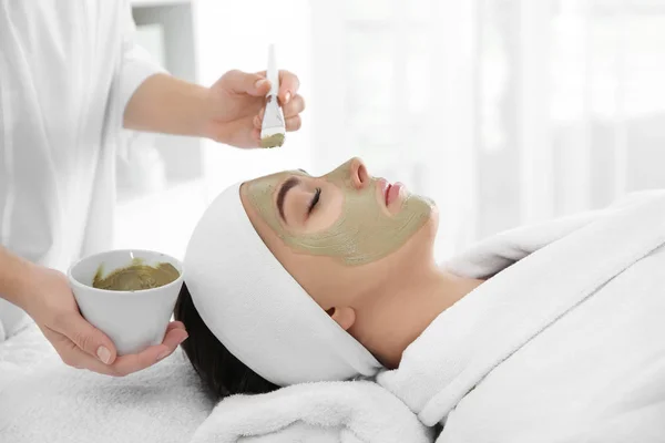 Schoonheidsspecialist masker toe te passen op cliënt gezicht in spa salon — Stockfoto