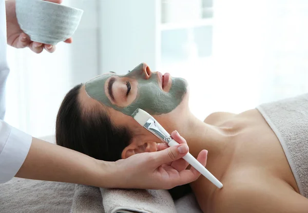 Schoonheidsspecialist masker toe te passen op cliënt gezicht in spa salon — Stockfoto