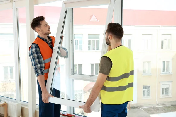Byggnadsarbetare installerar plast fönster i hus — Stockfoto
