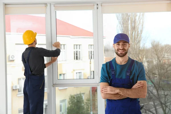 Byggnadsarbetare installerar plast fönster i hus — Stockfoto