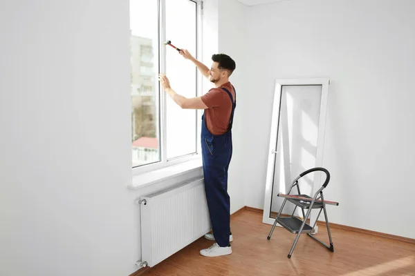 Professionelle Bauarbeiter installieren Kunststofffenster in Innenräumen — Stockfoto