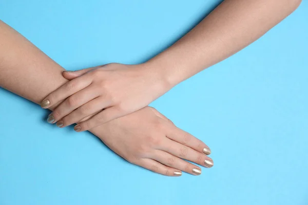 Mujer con manicura dorada sobre fondo de color, vista superior. Tendencias de esmalte de uñas — Foto de Stock