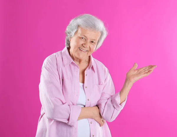 Porträtt av mormor i snygga kläder på färgbakgrund — Stockfoto