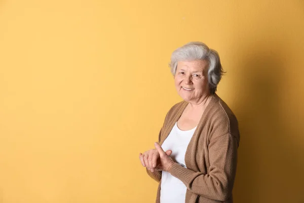 Retrato de avó em roupas elegantes em fundo de cor, espaço para texto — Fotografia de Stock
