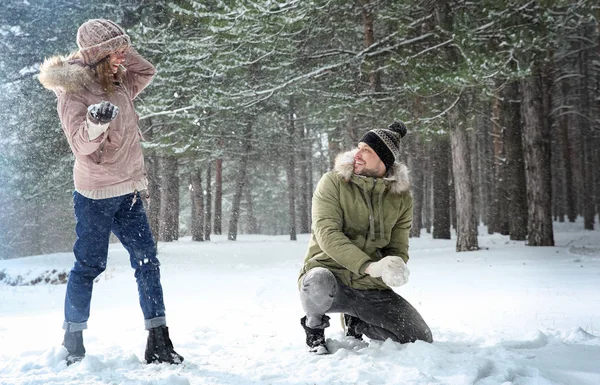 Ευτυχισμένο ζευγάρι παίζει χιονόμπαλες στο δάσος του χειμώνα — Φωτογραφία Αρχείου