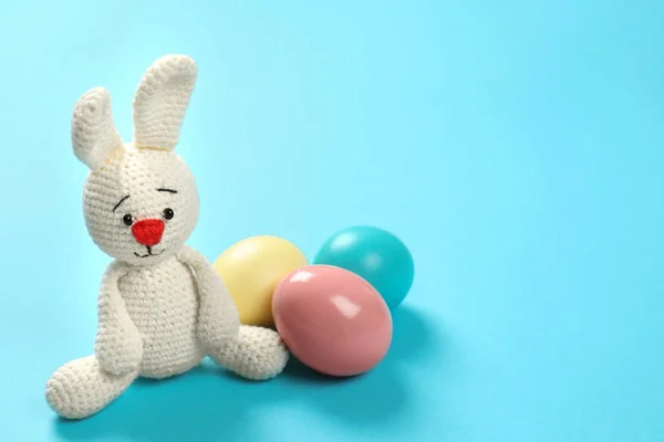 可爱的复活节兔子玩具和染色鸡蛋上的颜色背景, 文本空间 — 图库照片