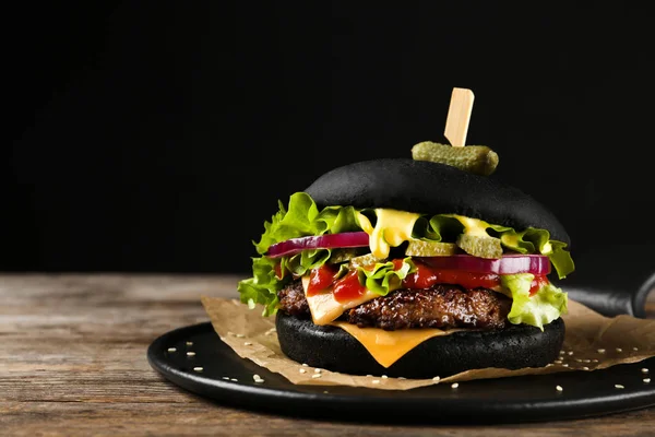 Leisteen plaat met zwarte Hamburger op tafel. Ruimte voor tekst — Stockfoto