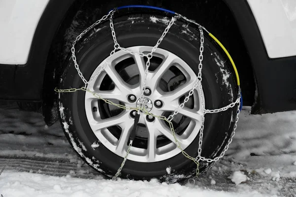 Auto met sneeuw ketting op band, close-up. Winterseizoen — Stockfoto