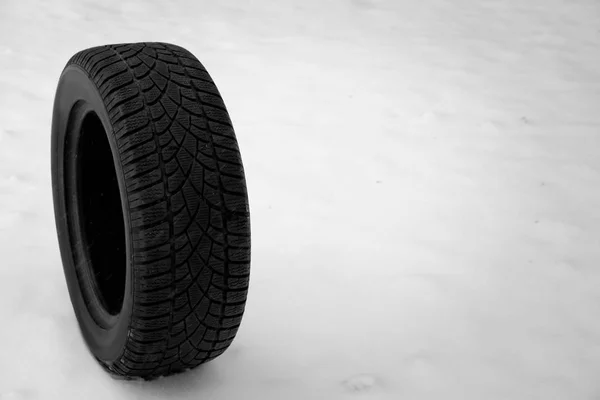 New winter tire on fresh snow. Space for text — Stock Photo, Image