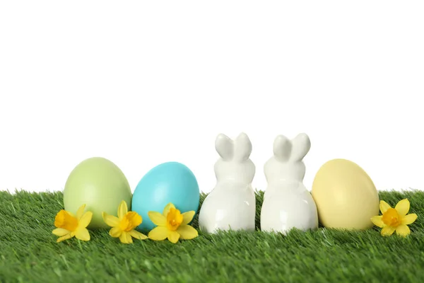 陶瓷复活节兔子和染色蛋在绿草对白色背景 — 图库照片
