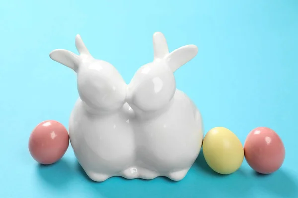 陶瓷复活节兔子和染色蛋在颜色背景 — 图库照片