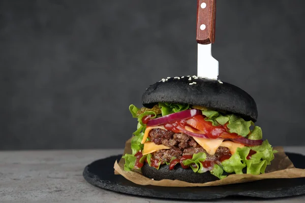 Břidlicová deska s černým burger na stole. Prostor pro text — Stock fotografie