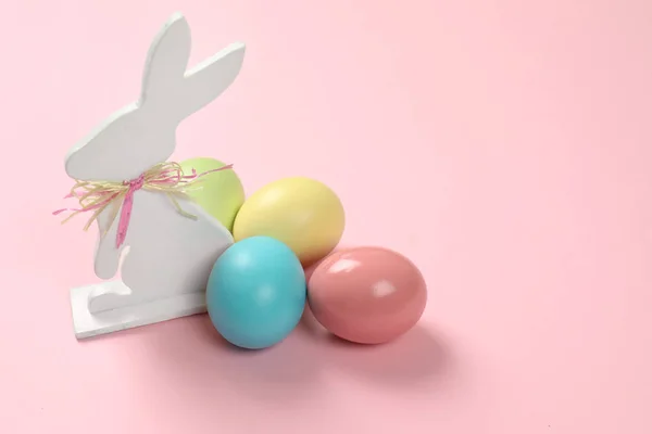 可爱的木制复活节兔子和染色鸡蛋上的颜色背景, 文本空间 — 图库照片