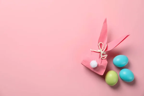 Flat lay composizione di sacchetto regalo coniglietto di Pasqua e uova tinte su sfondo di colore. Spazio per testo — Foto Stock