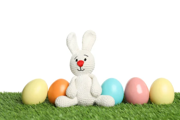 可爱的复活节兔子玩具和染色鸡蛋在绿草对白色背景 — 图库照片