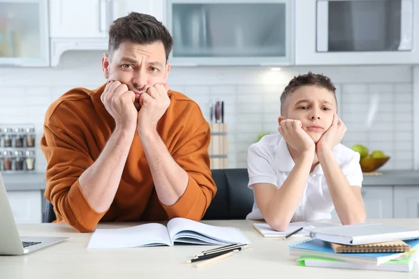 Papá ayudando a su hijo con tarea difícil asignación en la cocina — Foto de Stock