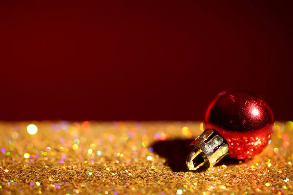 Golden paillettes and Christmas ball against color background. Space for text Royalty Free Stock Photos