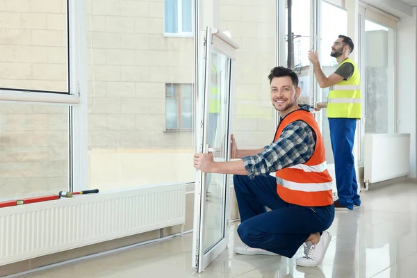 Construction workers installing plastic windows in house — Stock Image Construction workers installing plastic windows in house Stock Image