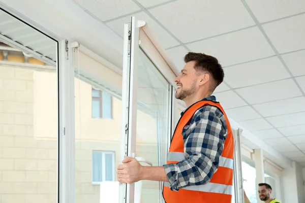 Construction worker installing plastic window in house — Stock Image Construction worker installing plastic window in house Royalty Free Stock Photos