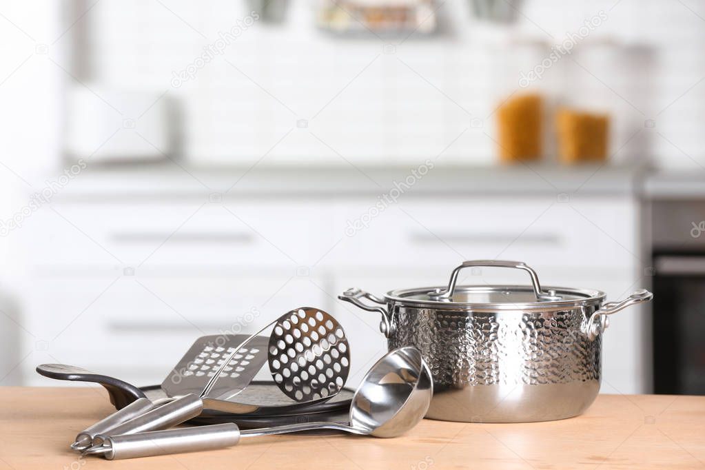 Set of clean cookware and utensils on table in kitchen. Space for text