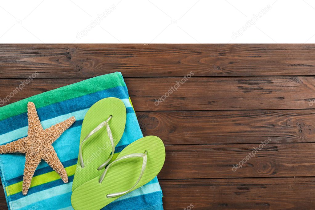 Flat lay composition with beach accessories on wooden background. Space for text