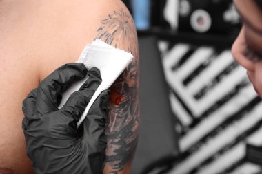 Profesyonel sanatçı kuaförde dövme yapıyor, yakın plan.