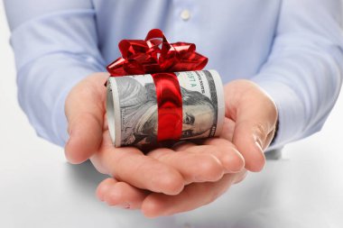Dolarlarına yay ile rulo beyaz arka planda, closeup tutan adam